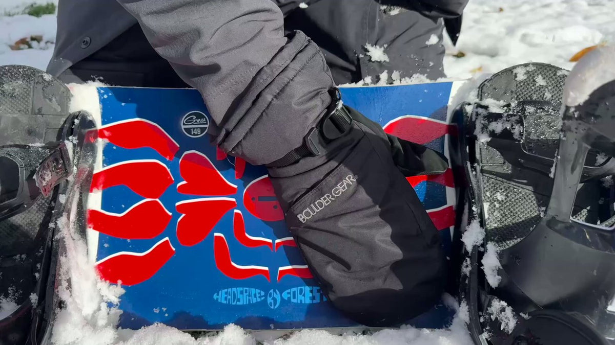 Applying Slope-X topcoat spray to the base of a snowboard