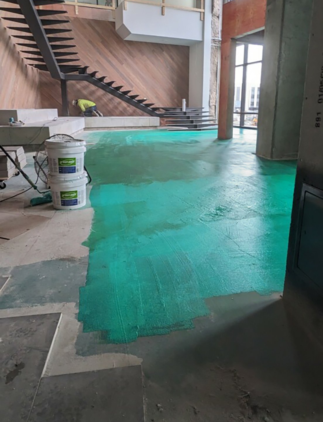 GreenSeel anti-fracture membrane applied across a concrete subfloor on a job site
