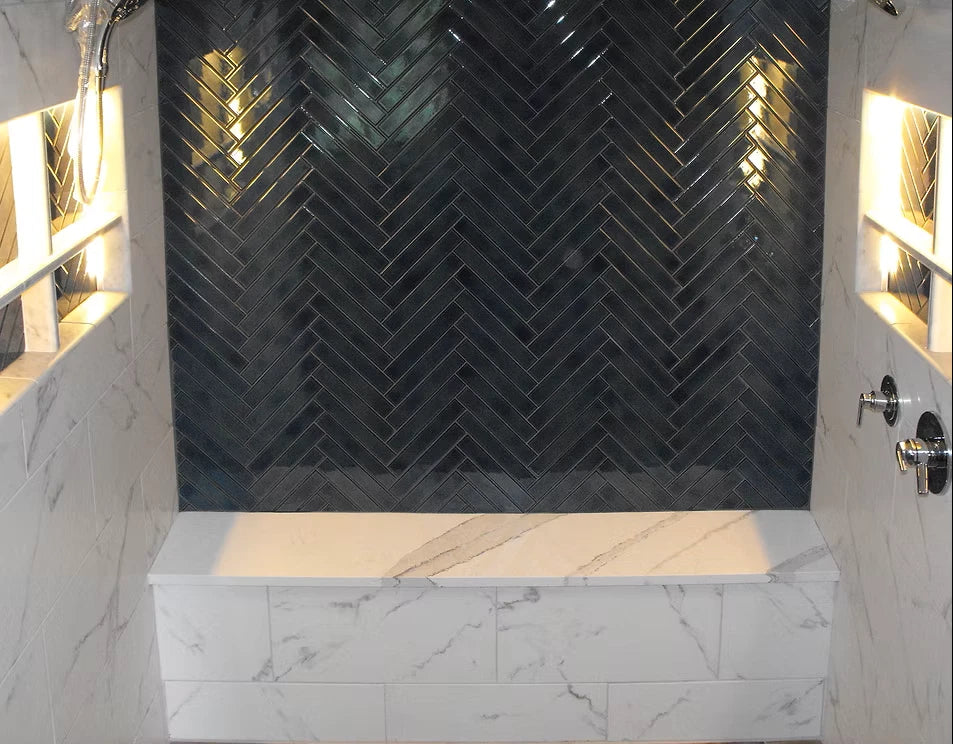 Finished herringbone tile shower wall and bench installed over GreenSeel waterproofing