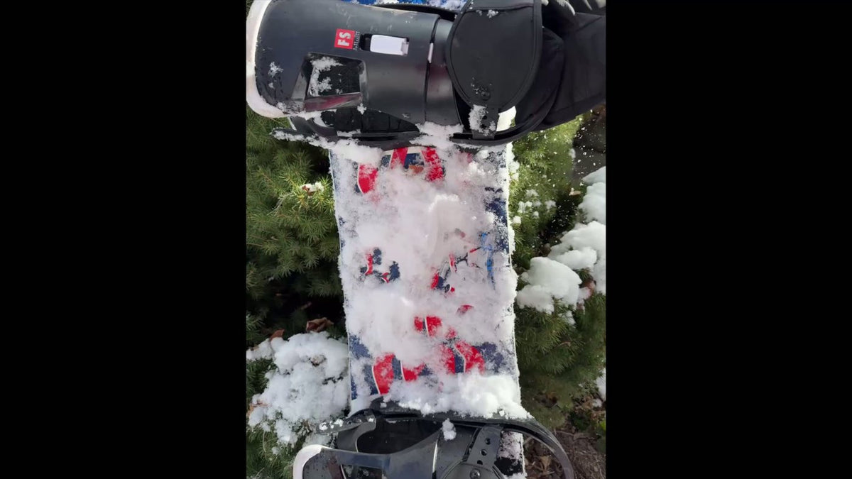 Heavy snow buildup on a snowboard before applying Slope-X