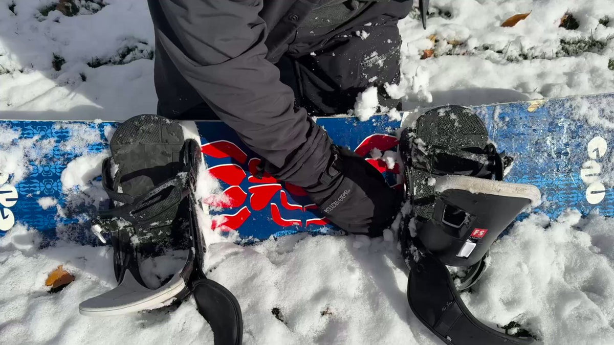 Snow packed around snowboard bindings and boots on an untreated board